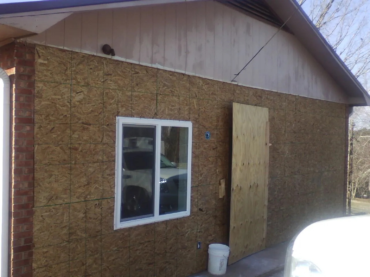 OSB sheathing on a garage addition wall before siding in Milligan