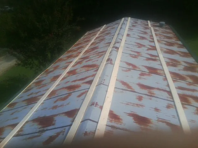 Rusted metal roof panels with new wood purlins before replacement — Storm Damage Roof Repair in Milligan by Roofing Brothers